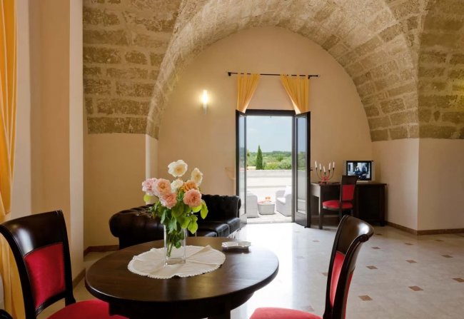 Salotto con soffitto ad arco e porta verso un terrazzo.