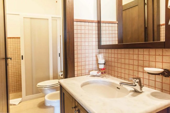 Bagno con lavabo, specchio e cabina doccia.