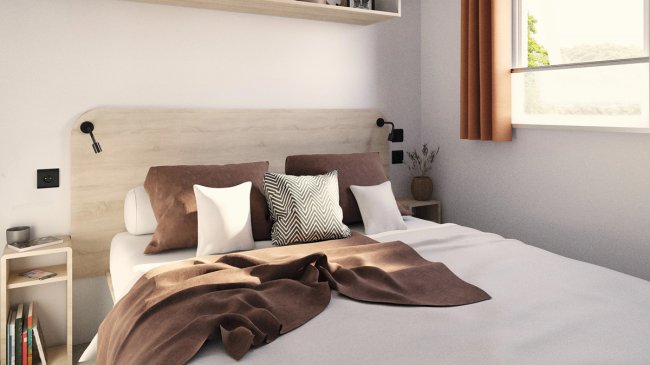 Camera da letto con letto matrimoniale, cuscini morbidi e coperta marrone.