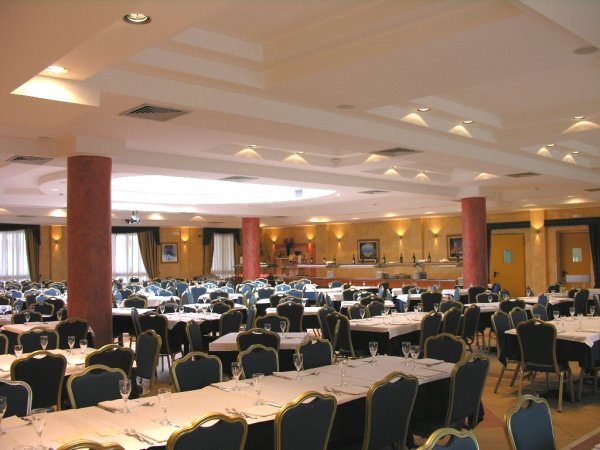 Sala da pranzo spaziosa con sedie nere e tavoli apparecchiati.