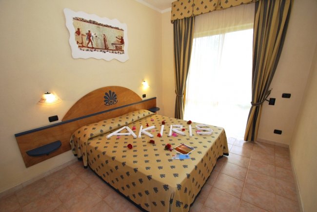 Camera da letto con letto matrimoniale e arte murale.