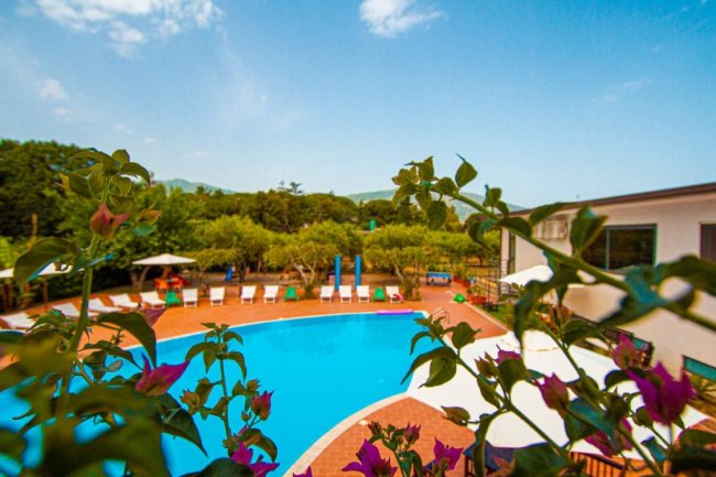 Piscina all'aperto circondata da sedie a sdraio.