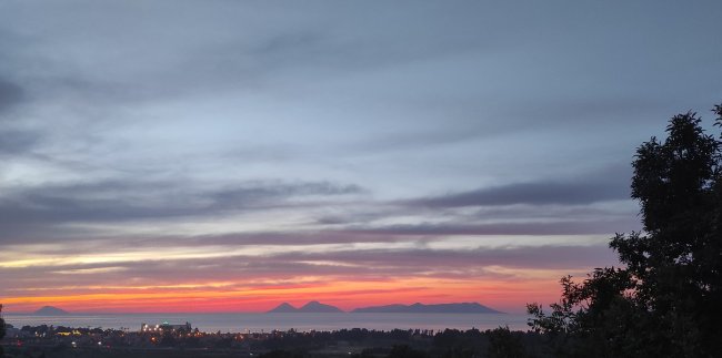 Vista di un tramonto con isole in lontananza.