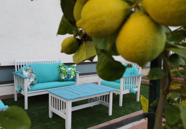 Limoni in primo piano con mobili da giardino blu sullo sfondo.
