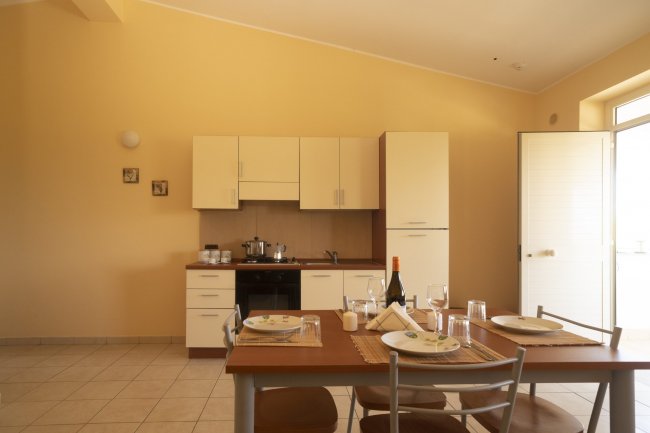 Cucina moderna con tavolo apparecchiato per quattro.
