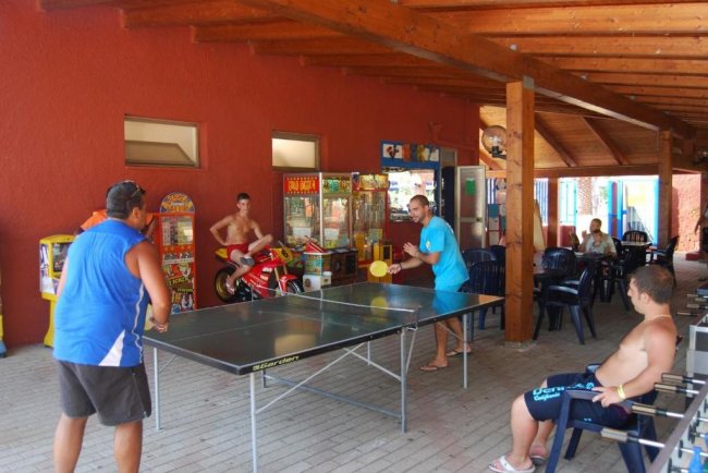 Due persone giocano a ping pong all'aperto.