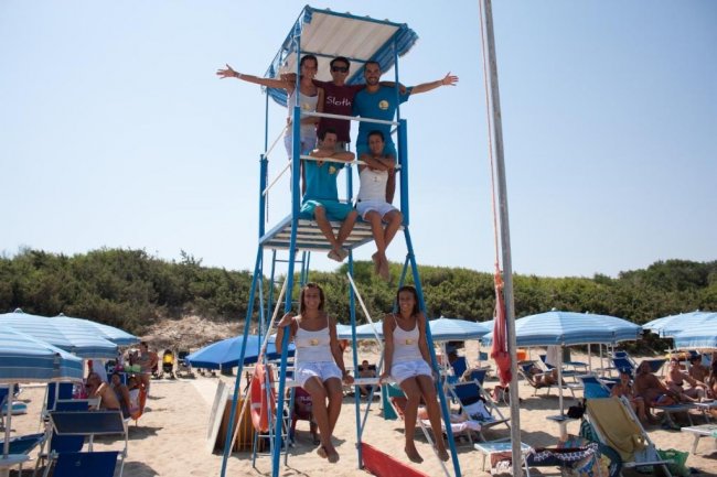 Persone su una torretta da bagnino in spiaggia.